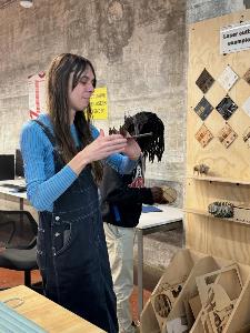 student looks at laser cut artifacts